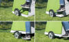 En person, der viser, hvordan man aktiverer hjulene på en hønsegård ved at trykke på håndtaget med foden