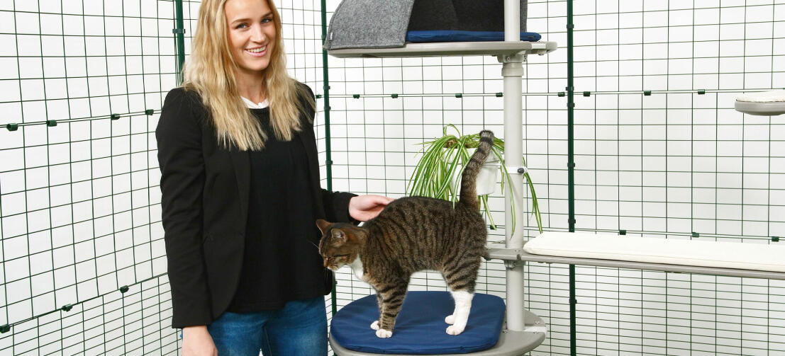 Pige klapper sin kat, der leger på Freestyle udendørs kattetræ