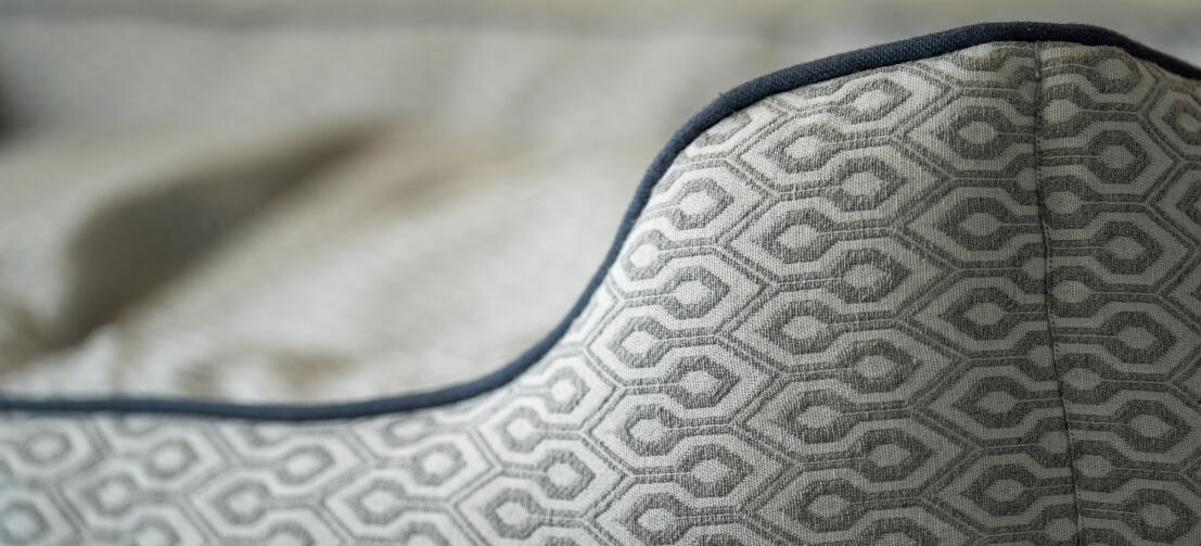 Nærbillede af sømdetaljer på rede-hundeseng med Honeycomb Slate-print.