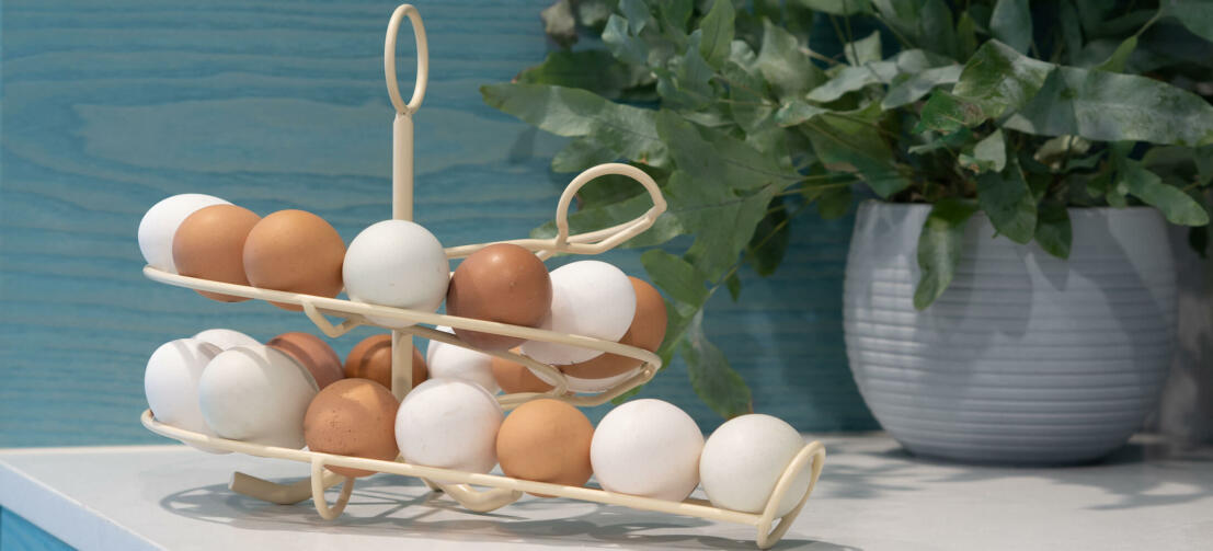 En cremefarvet Omlet æggekarrusel fuld af friske æg i et køkken