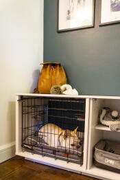 En hvid hund, der sover i en Fido Nook med skab og kasse