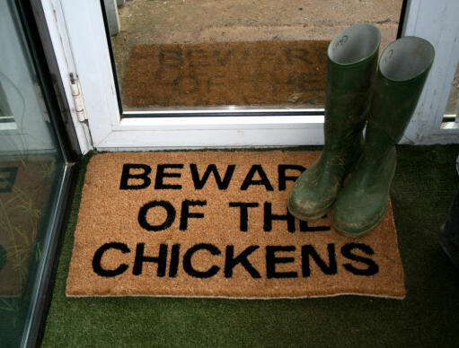 Pas på høns dørmåtte med gummistøvler på toppen