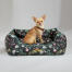Chihuahua sidder i en Omlet rede-seng i Midnight Meadow-mønsteret