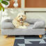 Hund sidder på Topology hundeseng med bolster og træfødder Hund sidder på Topology hundeseng med bolster og træfødder