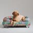 En Goldendoodle hviler på toppen af Pawsteps Electric hundeseng med støttekant En Goldendoodle hviler på toppen af Pawsteps Electric hundeseng med støttekant