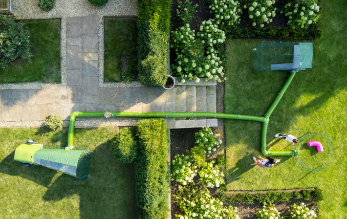 Droneoptagelse af Zippi løbegård, kravlegård og tunnelsystem opstillet i en have.