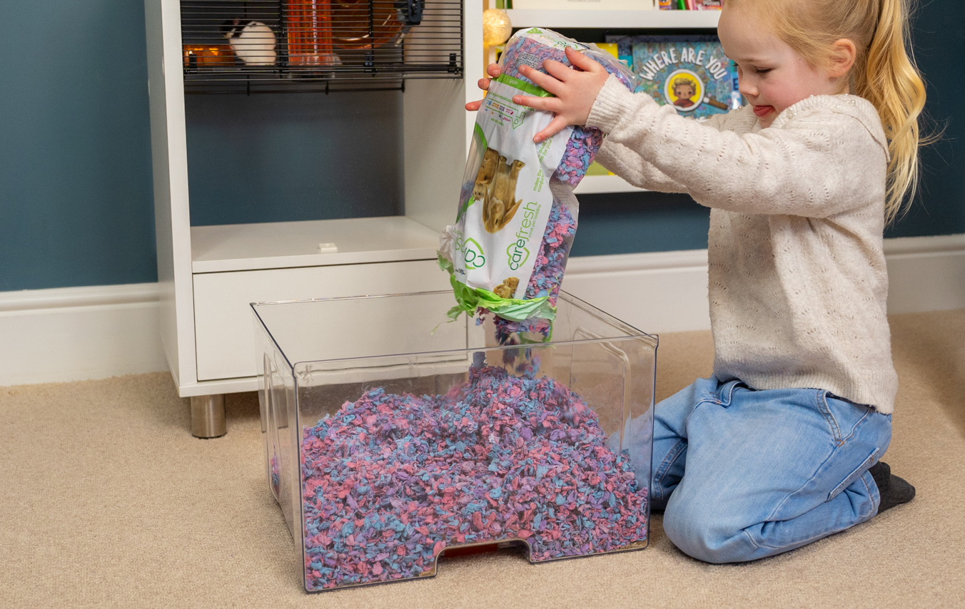 barn, der rengører en bundbakke i et Qute hamsterbur