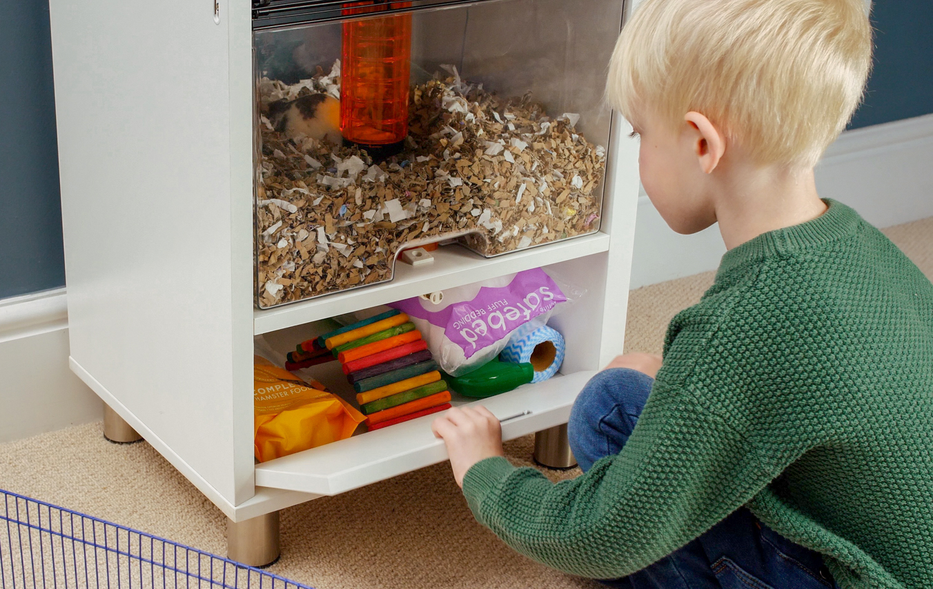 Barn putter bundmateriale i Qute hamsterburets opbevaringsplads