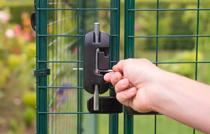 kvinde låser den sikre walk-in hønsegård